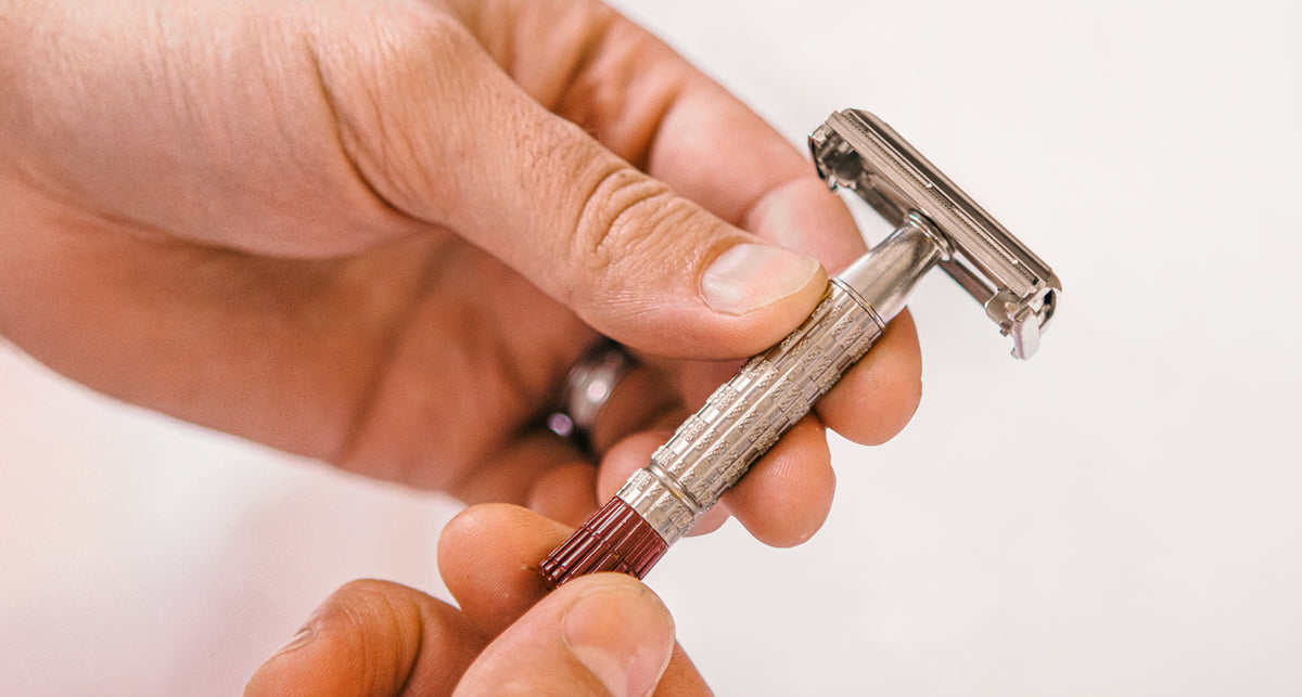 Hand holding a vintage safety razor